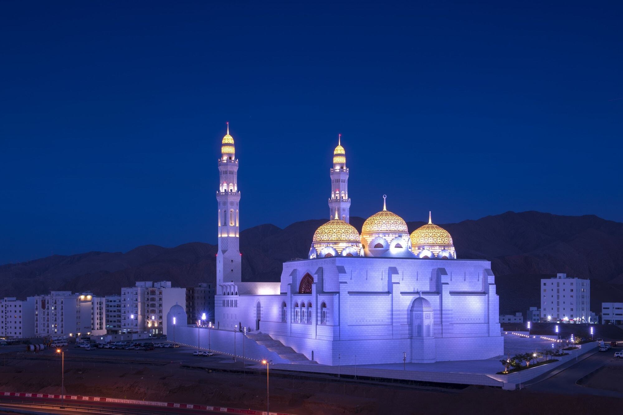 Fraser Suites Maskat Exterior foto The Qasr Al Bireh Mosque at night